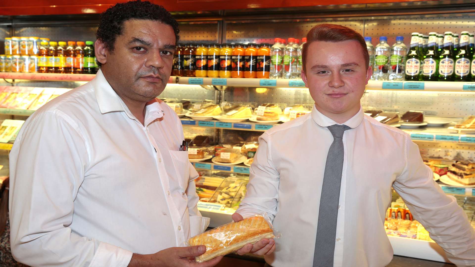 Chiappini's owner Xaver Figeiredo handing reporter Joshua Coupe a sausage roll