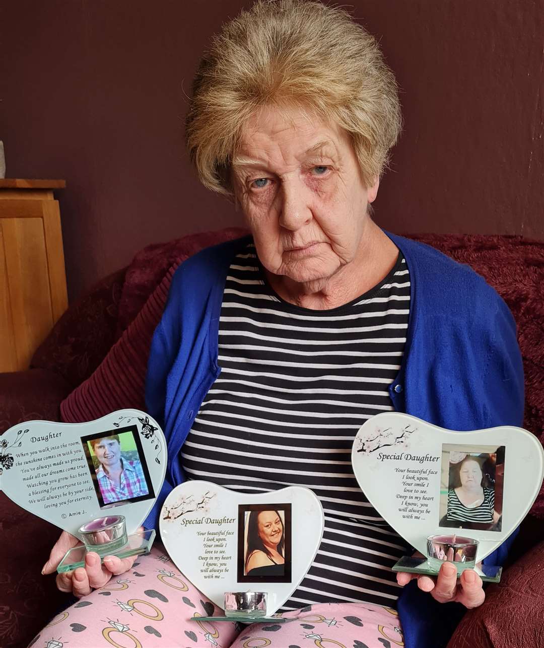 Denise Aitcheson holding pictures of her three daughters, Lisa, Laura and Louise