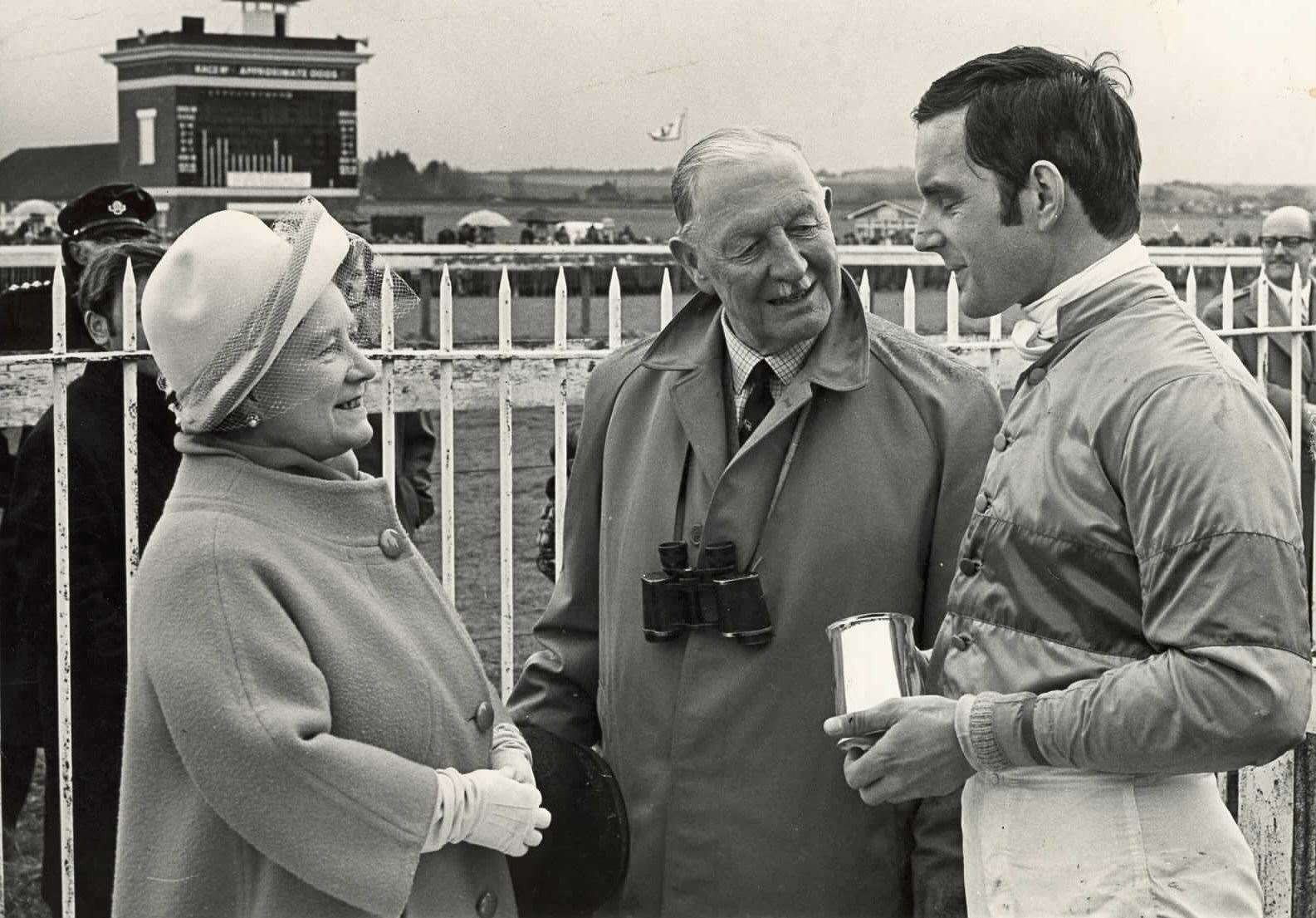 Queen Elizabeth, the Queen Mother, chats to David Mould after presenting him with the trophy for winning the Whitbread Elephant Steeplechase at Folkestone in 1970. Pictured in the centre is Lord Cornwallis