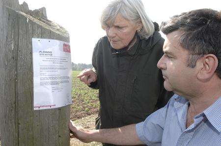 Julia Pender and David Luck inspect the planning notice for the proposed compost plant site in Venson Road, Tilmanstone.