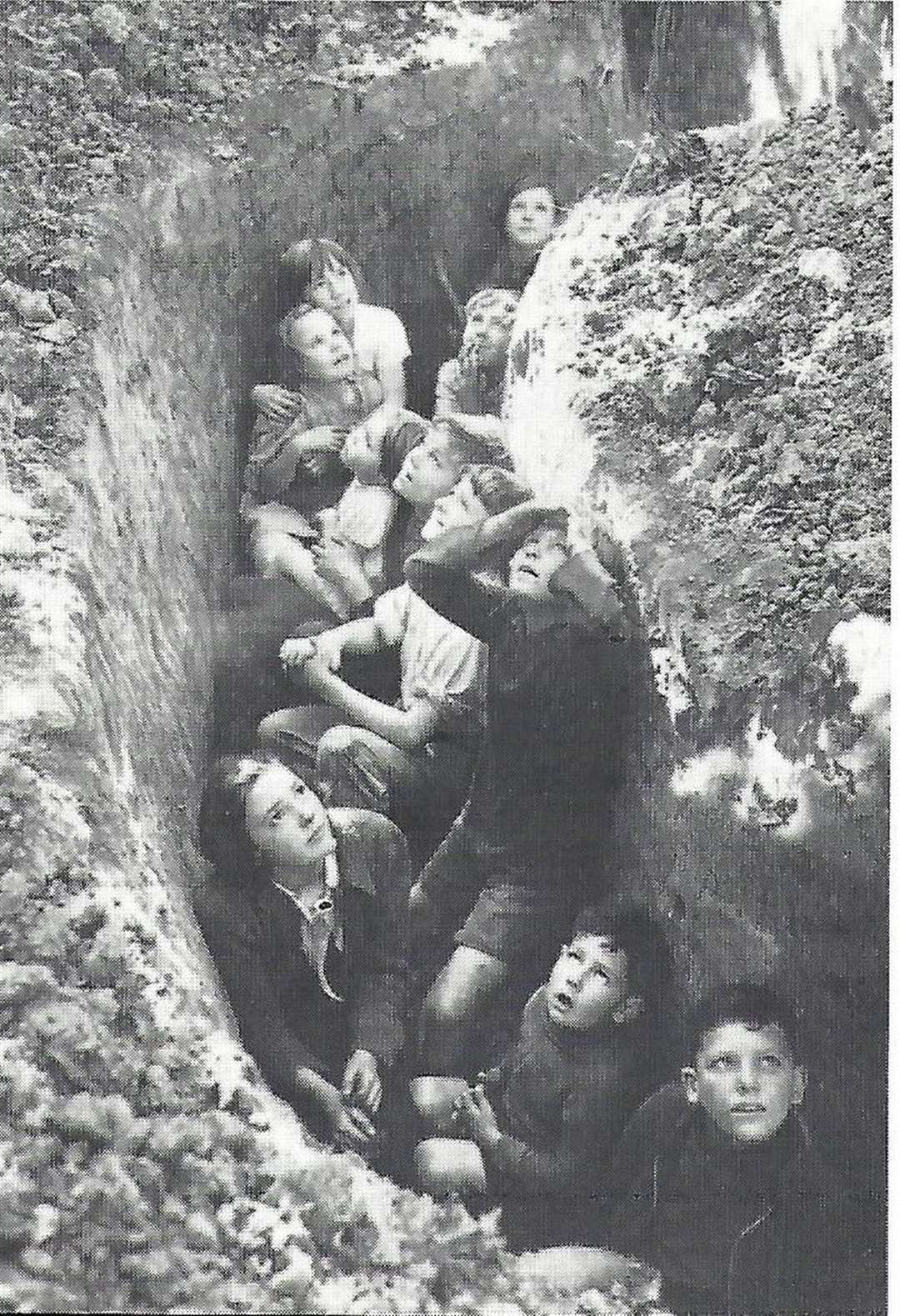 Children in Paddock Wood shelter in a trench as they watch a dogfight overhead in 1940