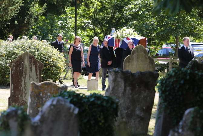 Mourners walk behind the hearse