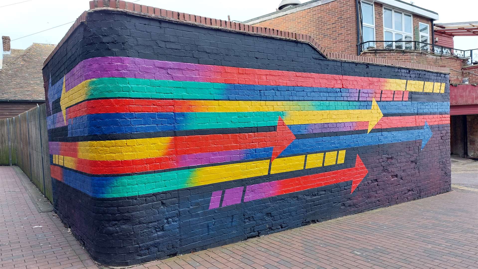 A mural by Charley Peters shows a collection of colourful arrows