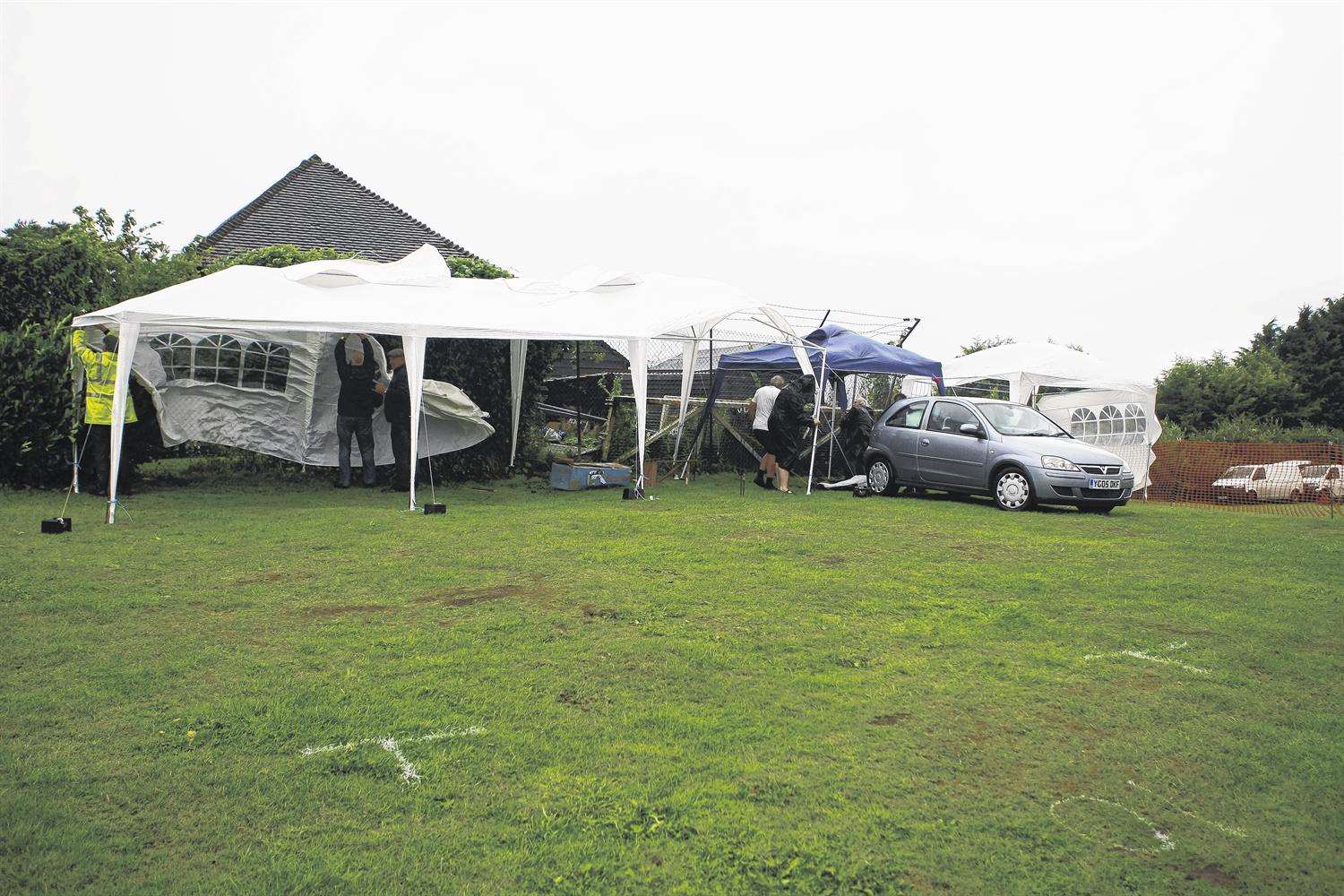 Volunteers struggle to keep gazebos in place during the Hurricane Bertha winds.