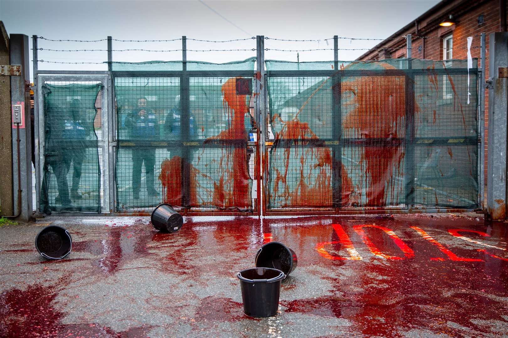 Activists threw fake blood at the gates on Thursday in protest to the arrangement at Napier Barracks. Photo by Andrew Aitchison