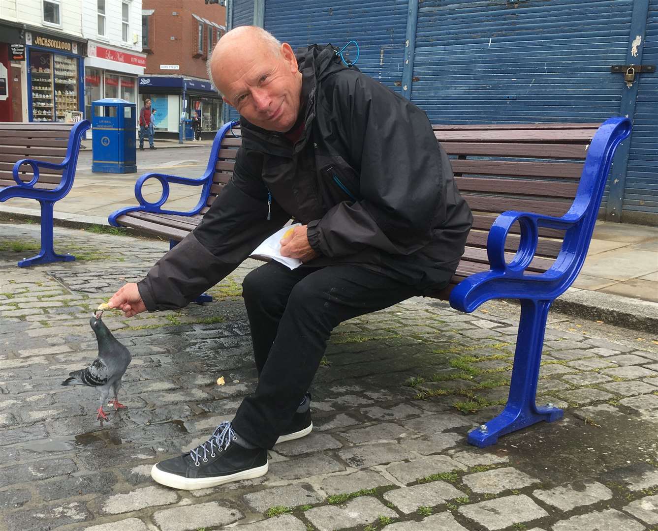 William Wallace, 74, from Seager Road tries out one of the refurbished benches as he feeds pigeons at Sheerness clock tower. Picture: John Nurden