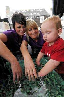 Donna Olliver-Hunn, left, and Natalie Cross, with 18-month-old eczema sufferer Mitchell Stephney at the fish tank