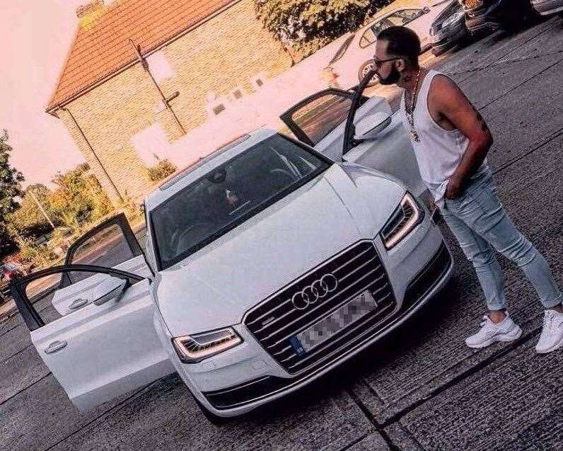 Mario Makula posing next to an Audi