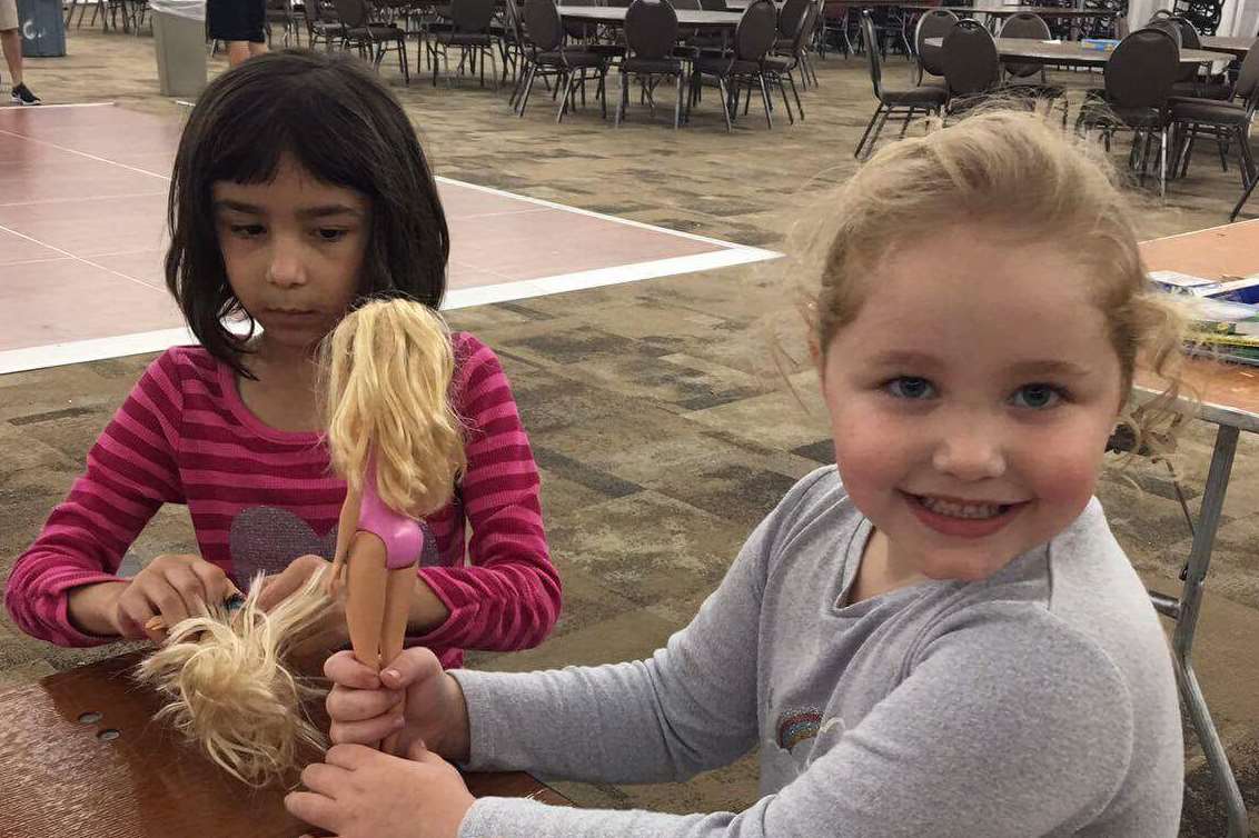 Little Darcey gives some of her dolls to a flood victim child in Houston