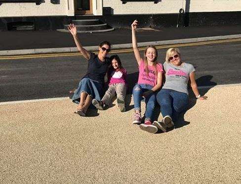 Barming residents Mia and Lilija Stockwell and Claire and Katie Dadswell celebrate the reopening of the A26 Tonbridge Road - by sitting on it!