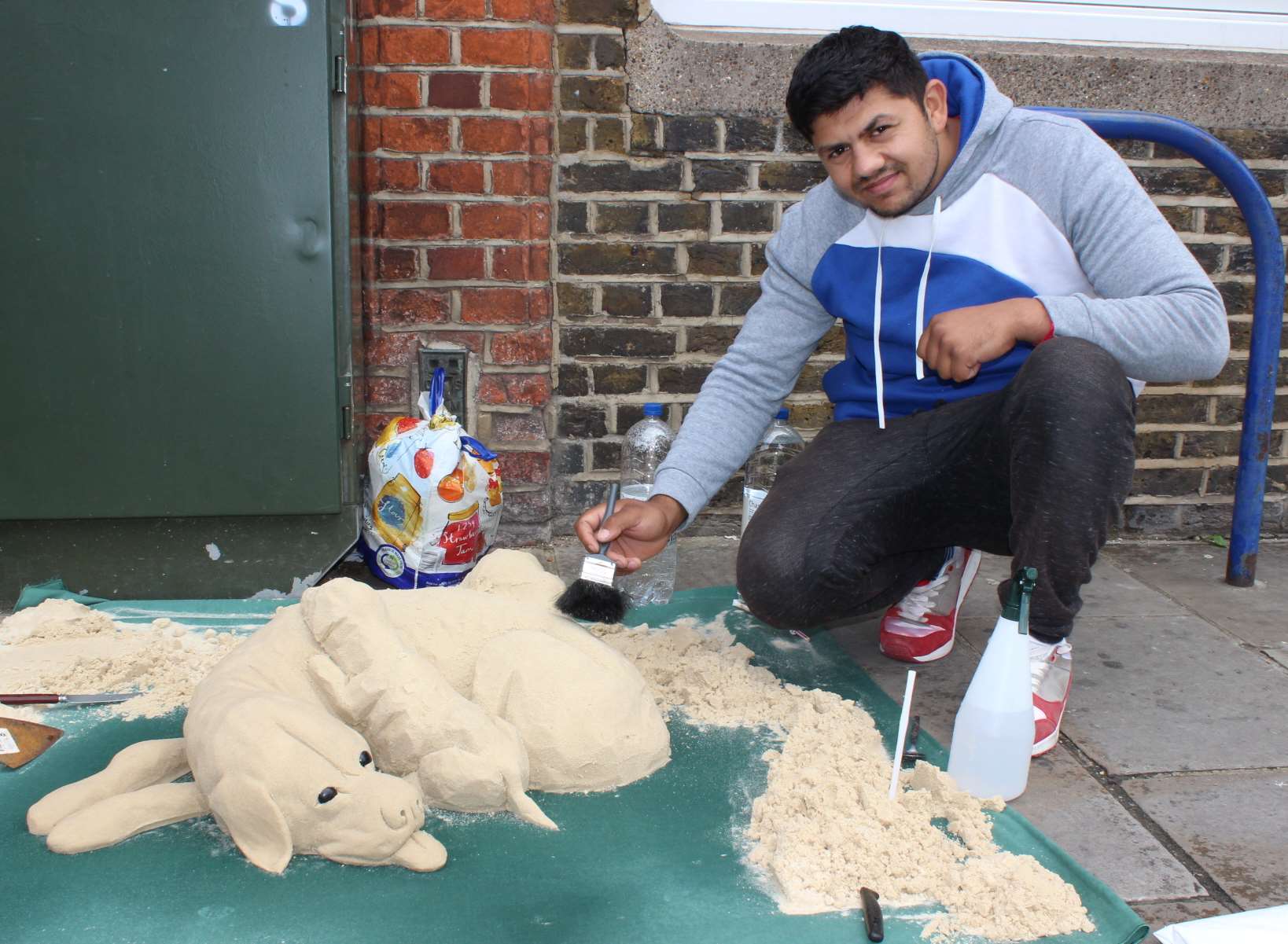 Sand man Steffan Tabac working on his model dog in Sheerness