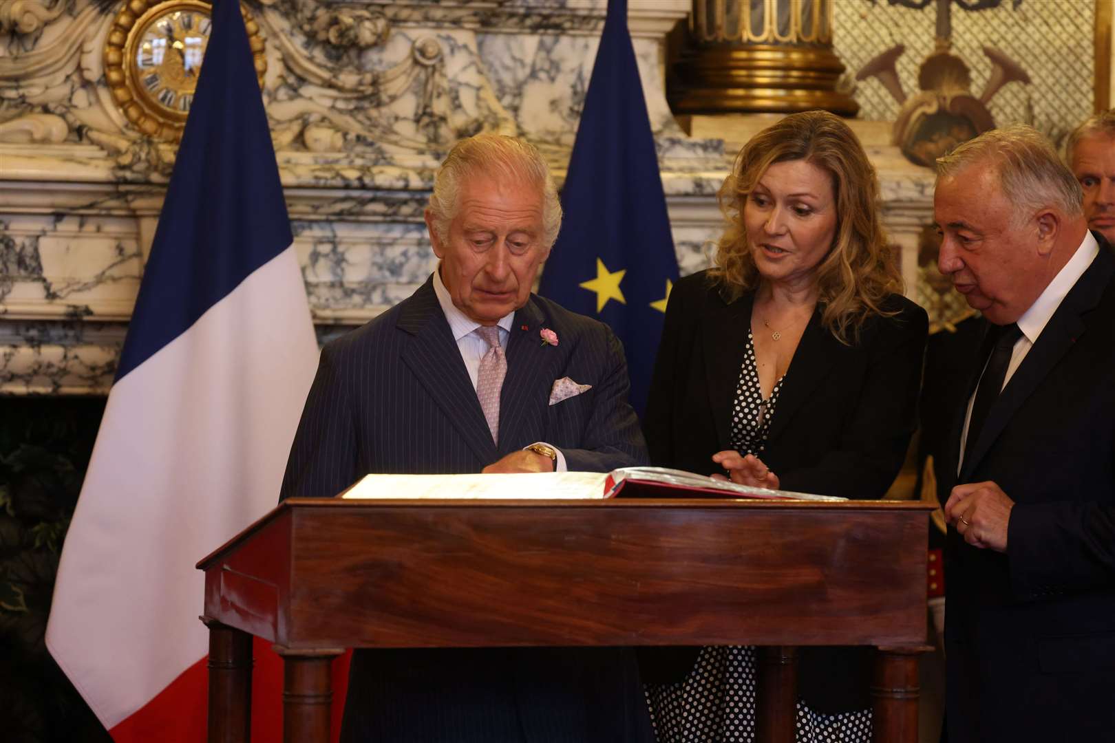 The King, with the President of the Senate Gerard Larcher and the National Assembly President Yael Braun-Pivet, signing the visitors book (Ian Vogler/Daily Mirror/PA)