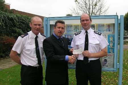 PC Chris Bryant (far right) and Ch Insp Ian Hall present a cheque to Ernie Brennan