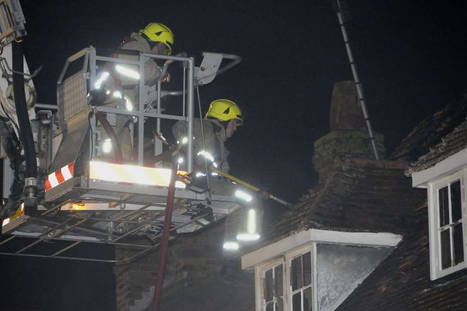 From a cherry picker, firefighters assess the damage. Picture: Paul Amos
