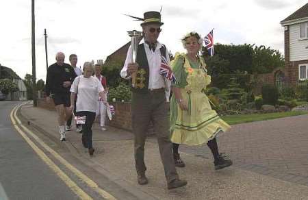 Peter Hicks, centre, with his wife Val, carrying the jubilee flame in 2002. Picture: ANDY PALMER