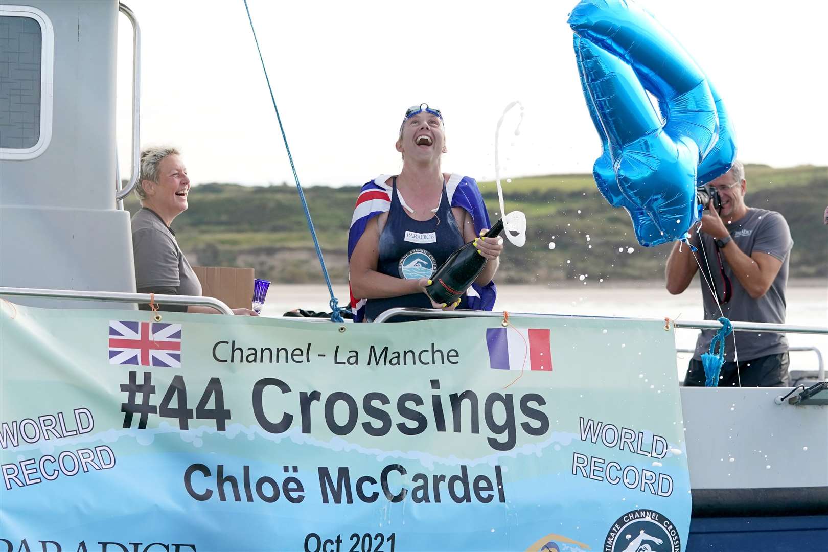 Chloe McCardel pops the cork on a bottle of champagne after completing her swim across the English Channel for a 44th time and breaking the world record (Gareth Fuller/PA)
