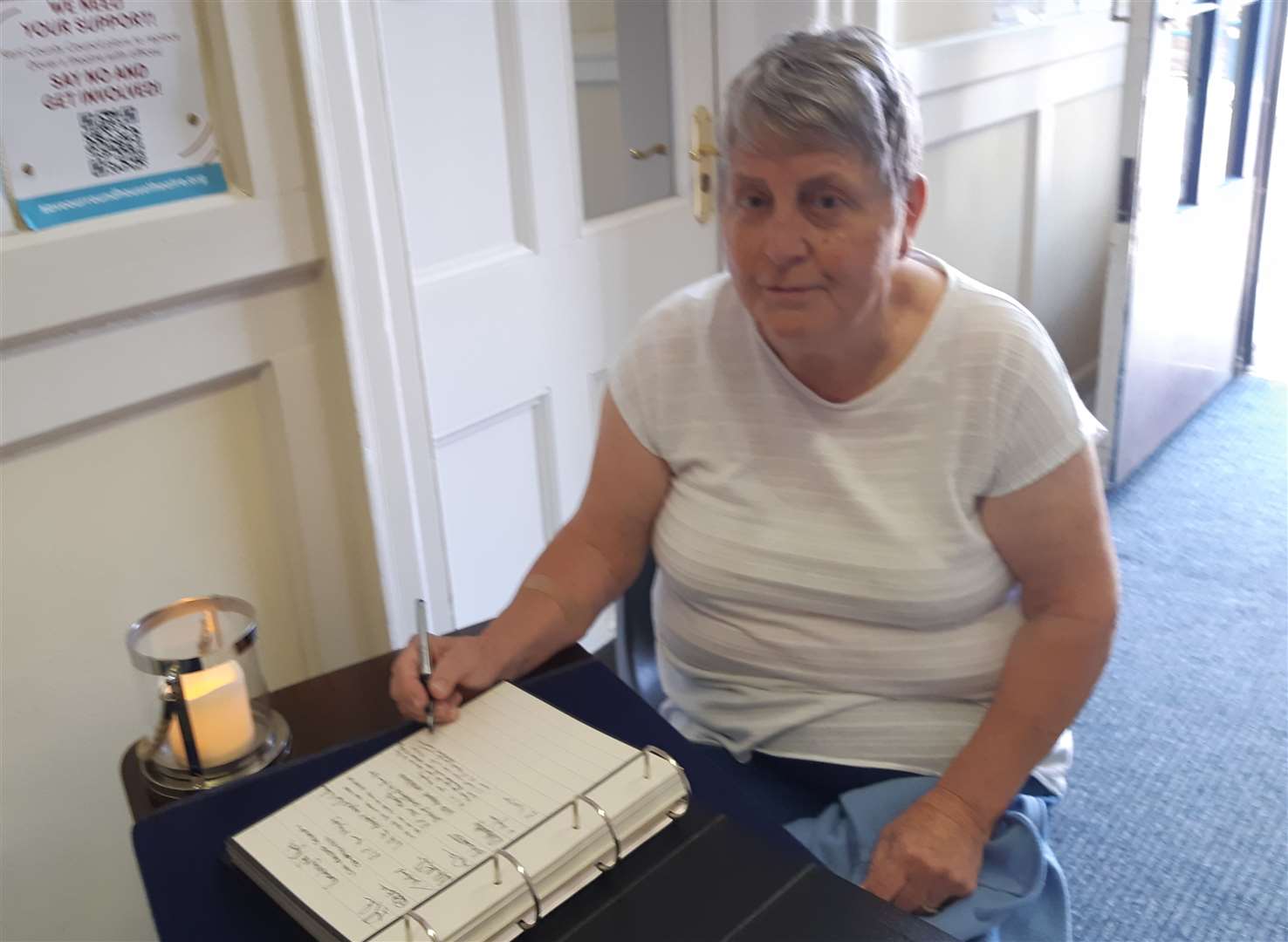 Linda Iverson signing a book of condolence at Dover Town Council's offices
