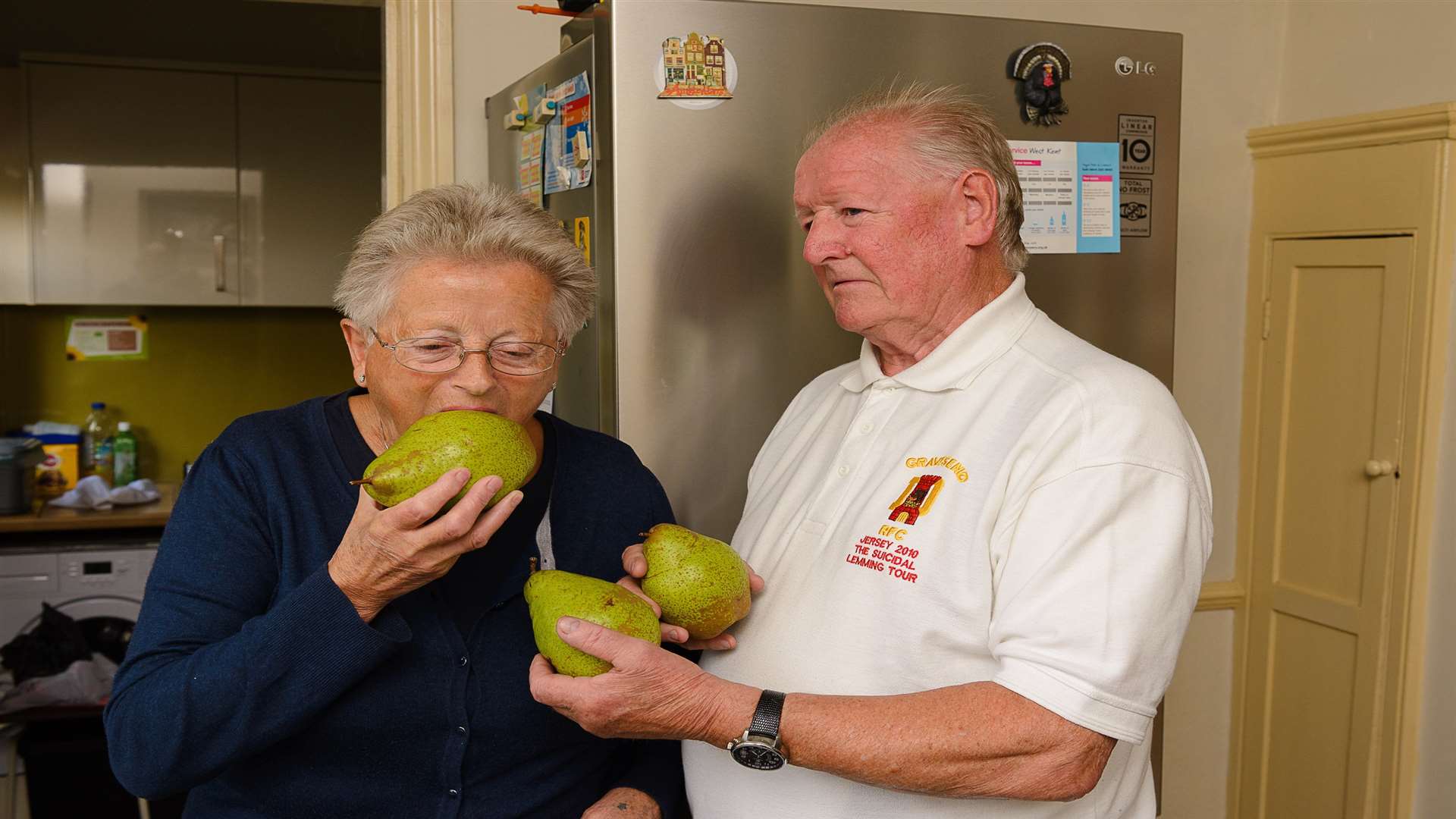 Terry Medes with his partner, Elke, taking a bite from one of the pears from his crop