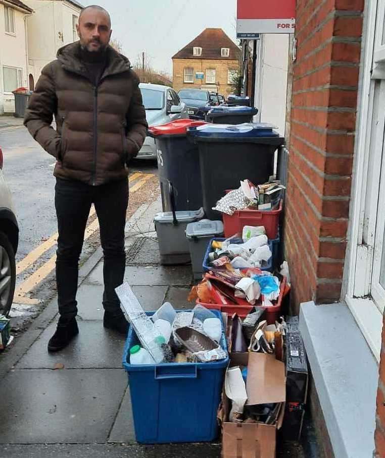 Dean Garbett pictured next to a pile of uncollected recycling in Canterbury