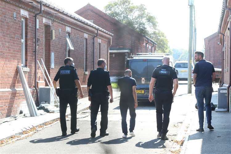 Police officers are escorted around Napier Barracks. Picture: Gareth Fuller/PA