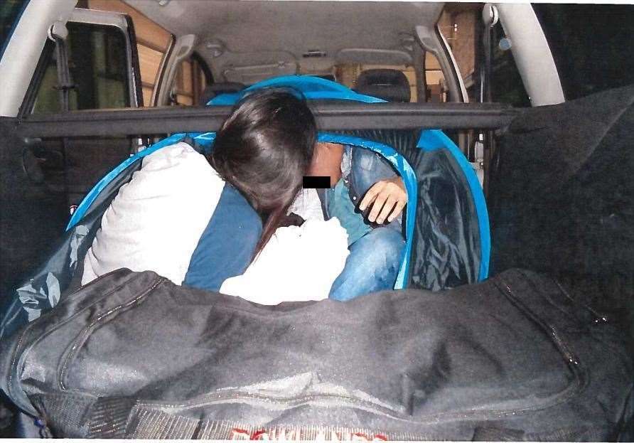 A tent is used to hide someone in a car