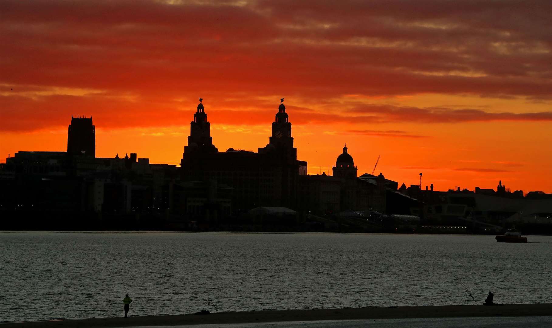 The sun rising behind the Liver Building over the Liverpool waterfront (Peter Byrne/PA)