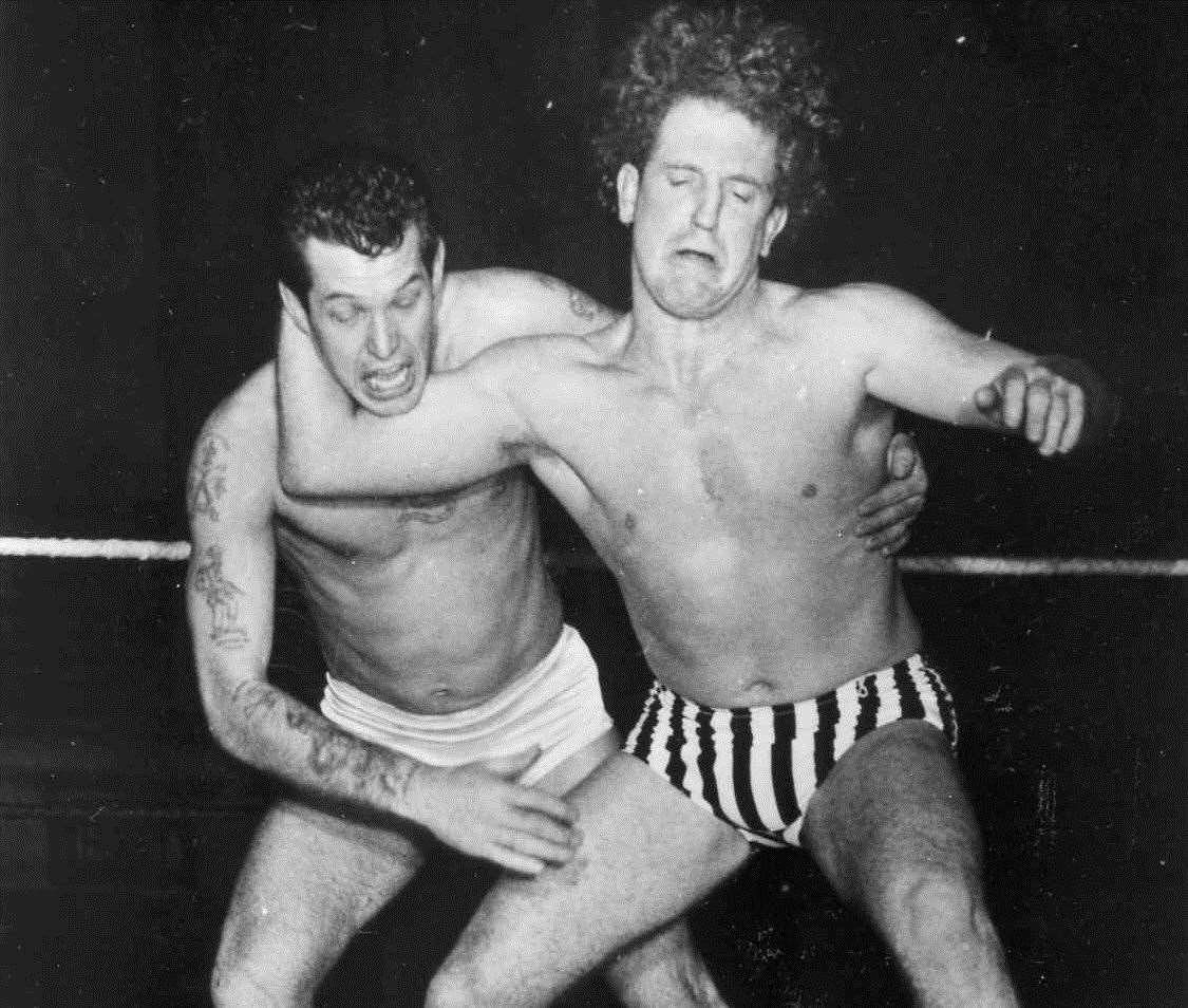 Wrestler Jackie Pallo, right, in full swing putting Johnny Eagles in a head move