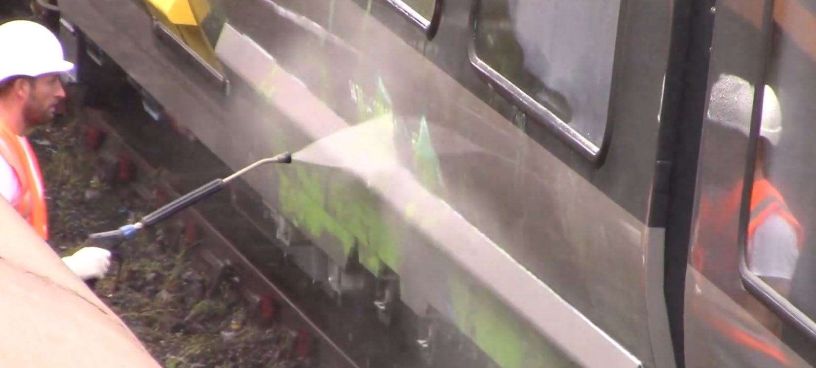 A rail man cleaning off the paint from one of the Merseyrail carriages which was attacked in Tonbridge. Picture: Nicholas Garner - Rail In Kent (YouTube)