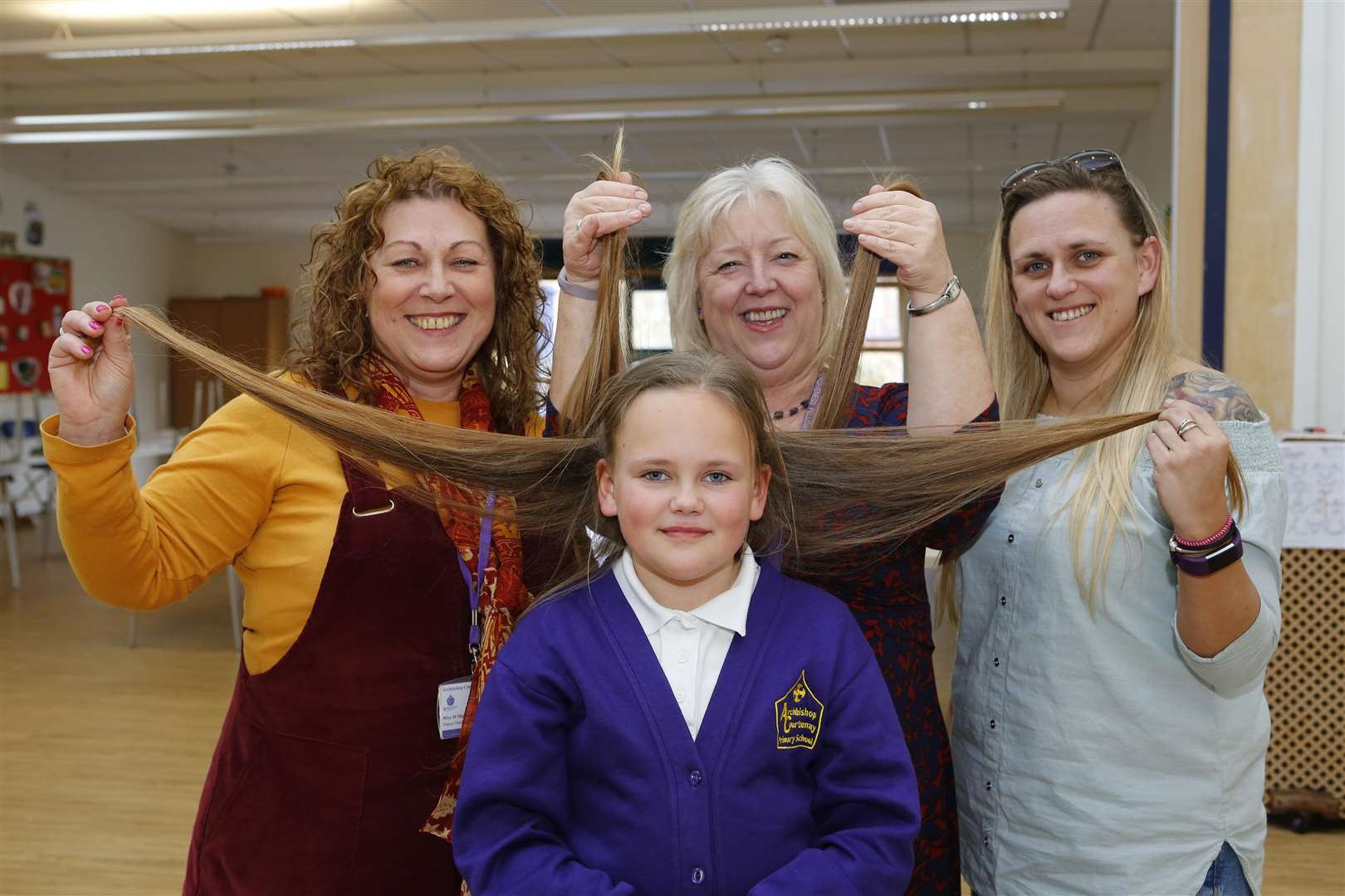 Ella Amess getting her hair cut for Make-A-Wish with Margaret Magner, deputy headteacher, Tracy Gooding, pastoral & wellbeing manager, and Emma Amess.