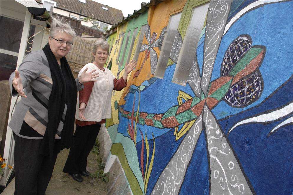 Dawn Cockburn of the Harmony Therapy Trust and Denise Dickson of Poppy Crafts with the mural painted by Richard Jeferies on the wall of the garage behind their shared building