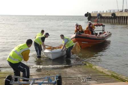 A 12-foot sailing dinghy is recovered by the lifeboat station shore party after the Whitstable Lifeboat towed the craft ashore