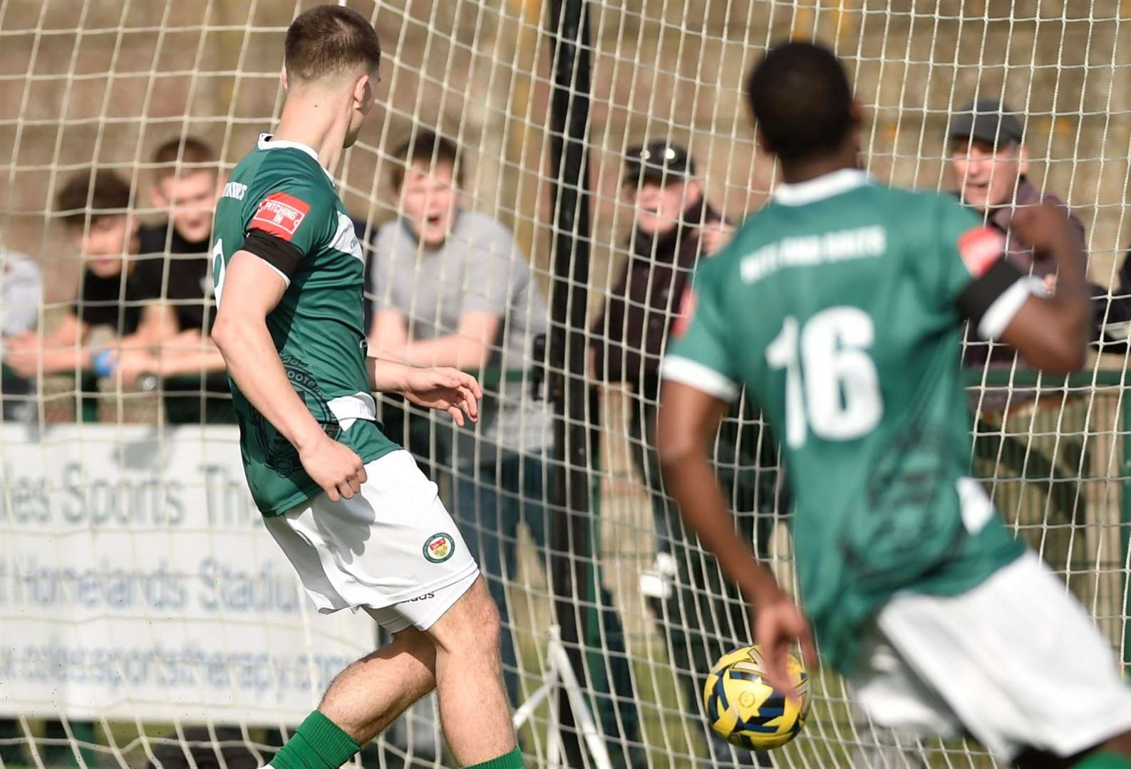 Noah Carney and Lanre Azeez see team-mate Robbie Rees find the net for a late Ashford consolation in a 3-1 loss to Chichester. Picture: Ian Scammell