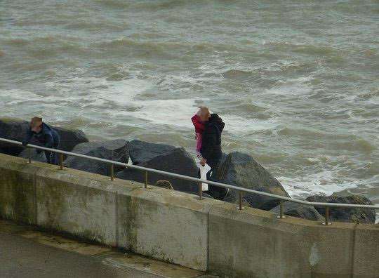 The man holding the young girl balances precariously on the rocks. Picture: Kent999s