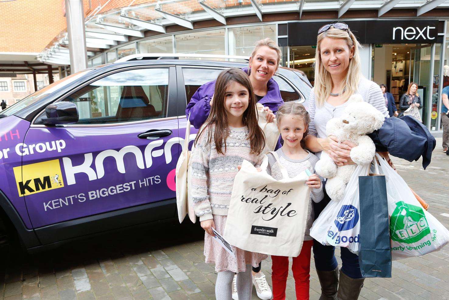 Kmfm's Caroline Stark hands out bags to Tracy Gilmore and youngsters Darcey Gilmore, 6, and Jessica Ryan, 8