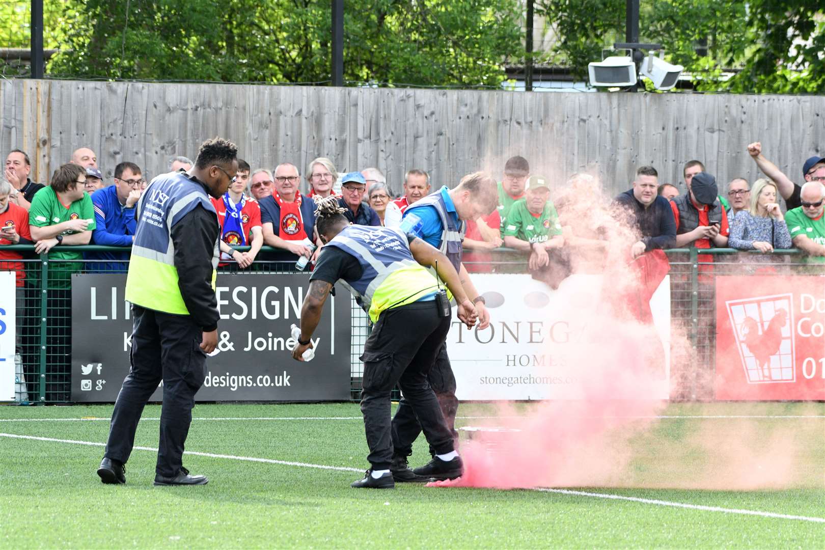 Stewards put out a smoke bomb that was thrown onto the pitch at Dorking. Picture: Barry Goodwin