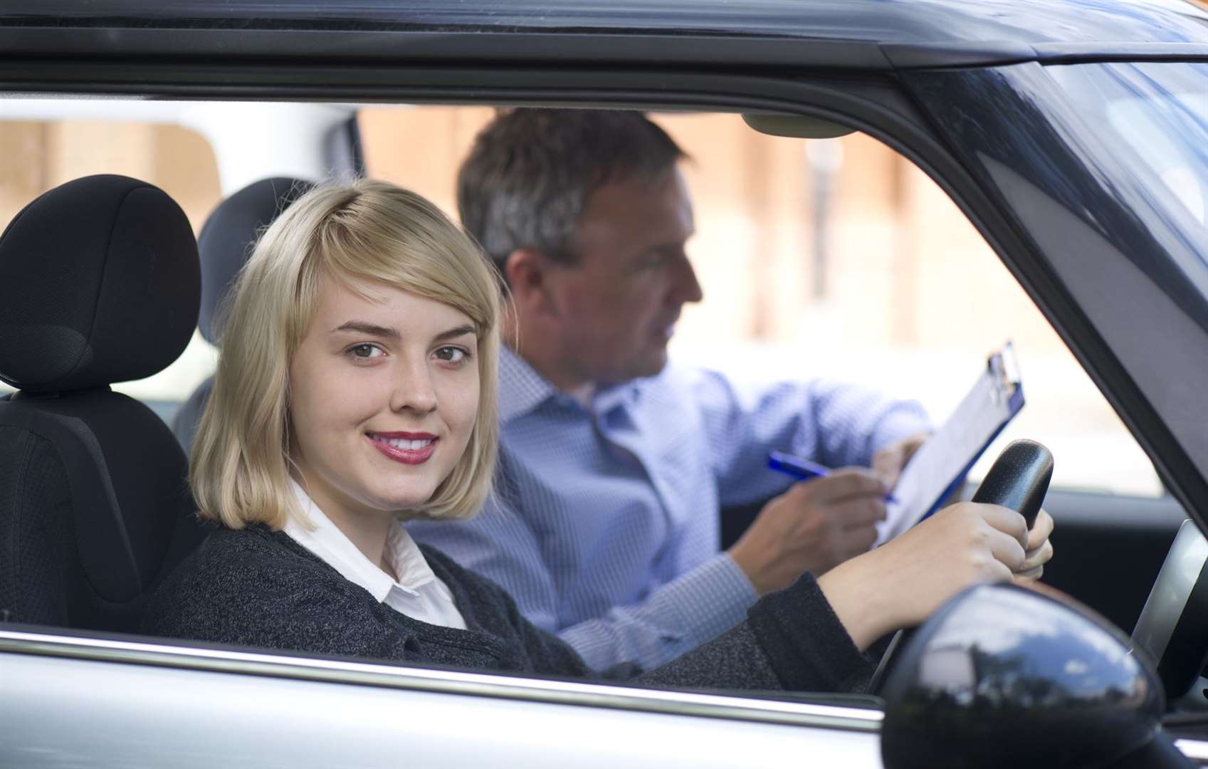 You can tell this is a posed stock image – does anyone look this relaxed on a driving test?