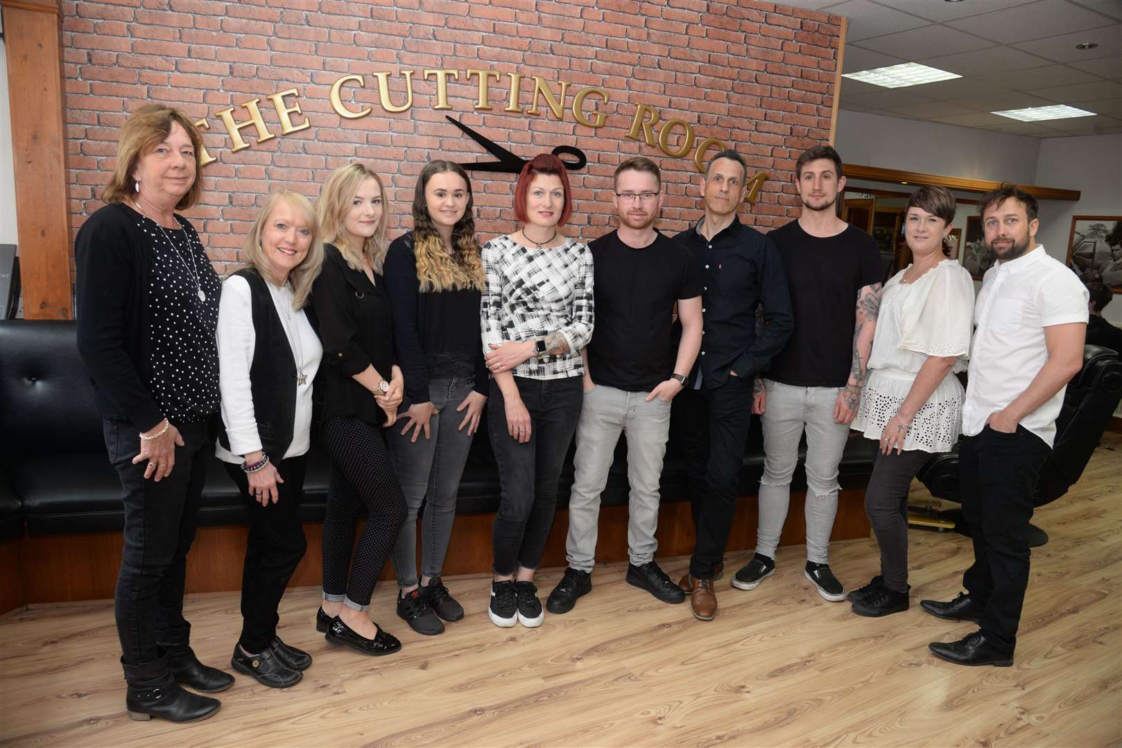 Chris Delsignore, left and her son Lee Wood, right with their staff at the Men's Cutting Room in Queen Street, Deal who are celebrating 20 years in business