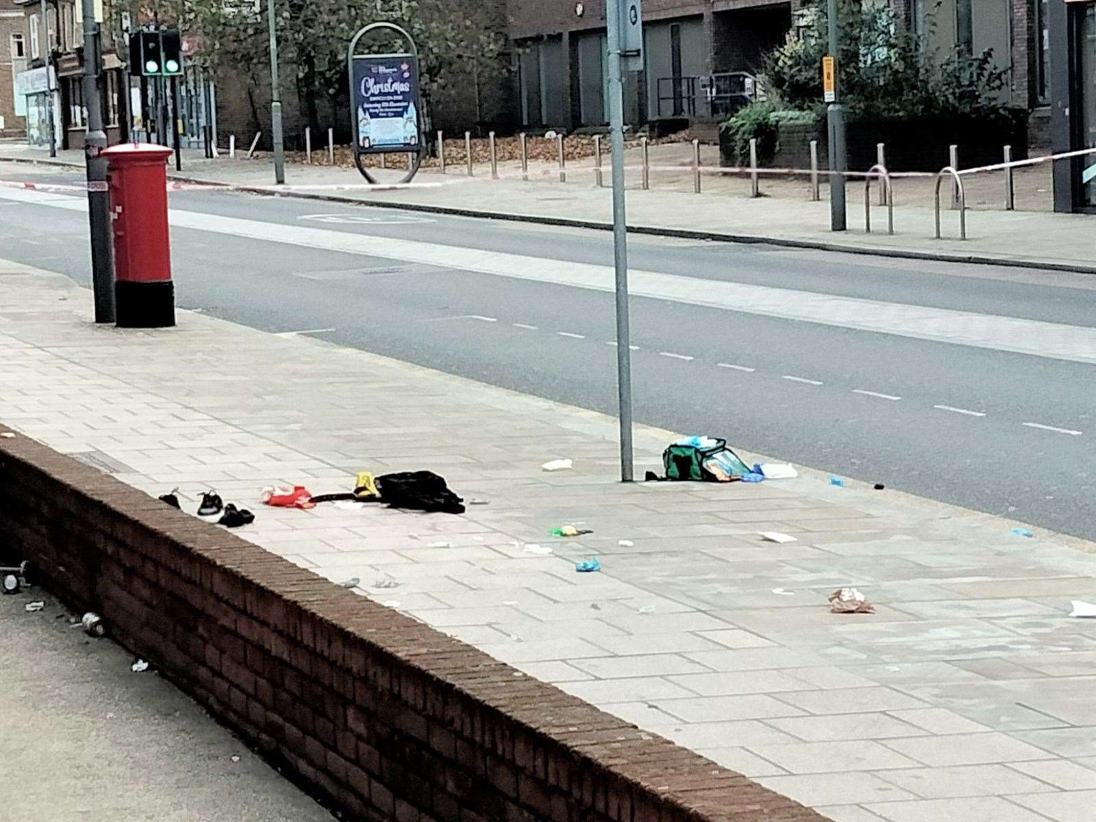 A medical bag and discarded clothes have been left on the pavement