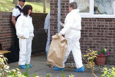 Police scenes-of-crime officers at the property where the body was found. Picture: MIKE PETT