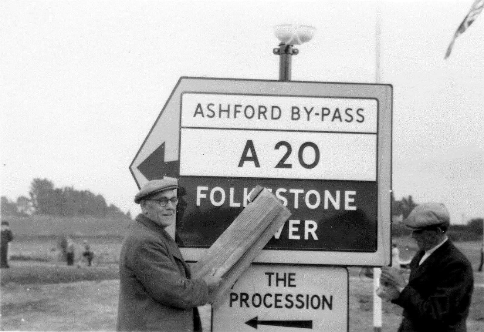 Workmen uncover the signage for the new bypass