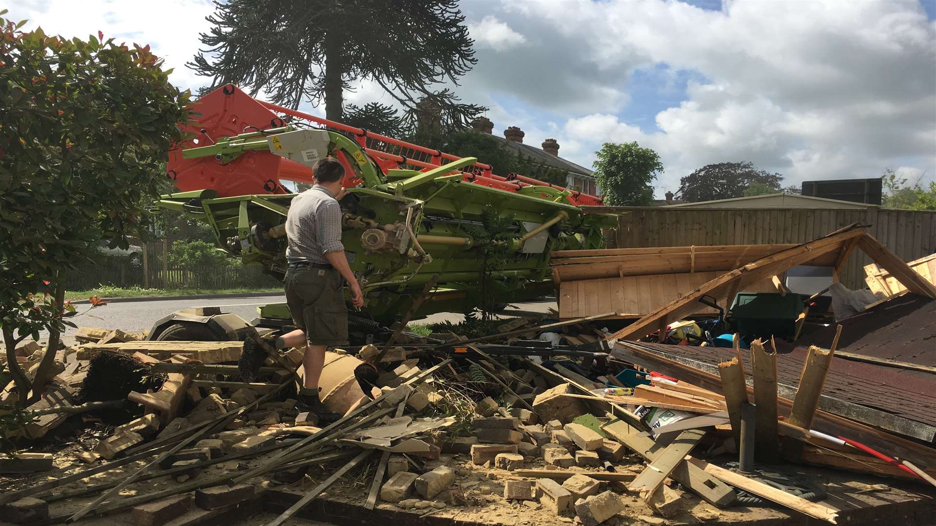 A man stands amid the rubble in the demolished garden