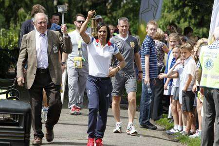 Dame Kelly Holmes runs with the Olympic torch at Tonbridge Castle with Frank Verge