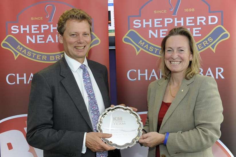 Geraldine Allinson, chairman of the KM Group, presents Jonathan Neame, chief executive of Shepherd Neame, with a silver salver in recognition of the brewery's decade of supporting the KM Big Charity Quiz
