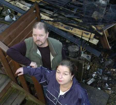 Mike Webb and Debbie Grew in one of the destroyed sheds. Picture: ANDY PAYTON