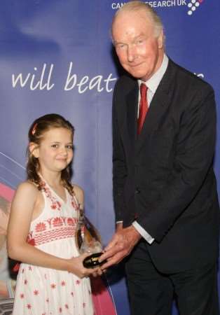 Chloe Gambrill, nine, receives her Flame of Hope award from David Newbigging, chairman of Cancer Research UK