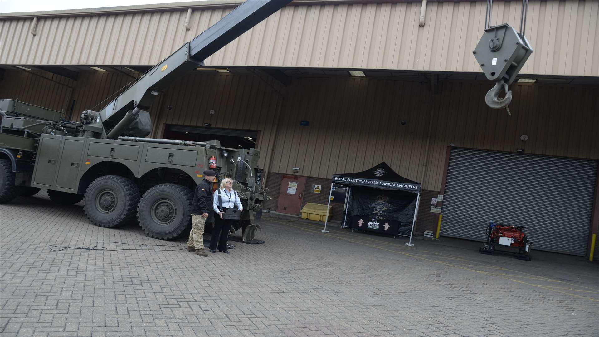 L Cpl James Hamilton of the Royal Electrical and Mechanical Engineers coaches Mainstream's Melanie Baker on the controls of an army recovery vehicle during the open day