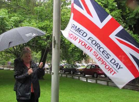 Cllr Jan Holben raises the flag for Armed Forces day outside the Civic Centre