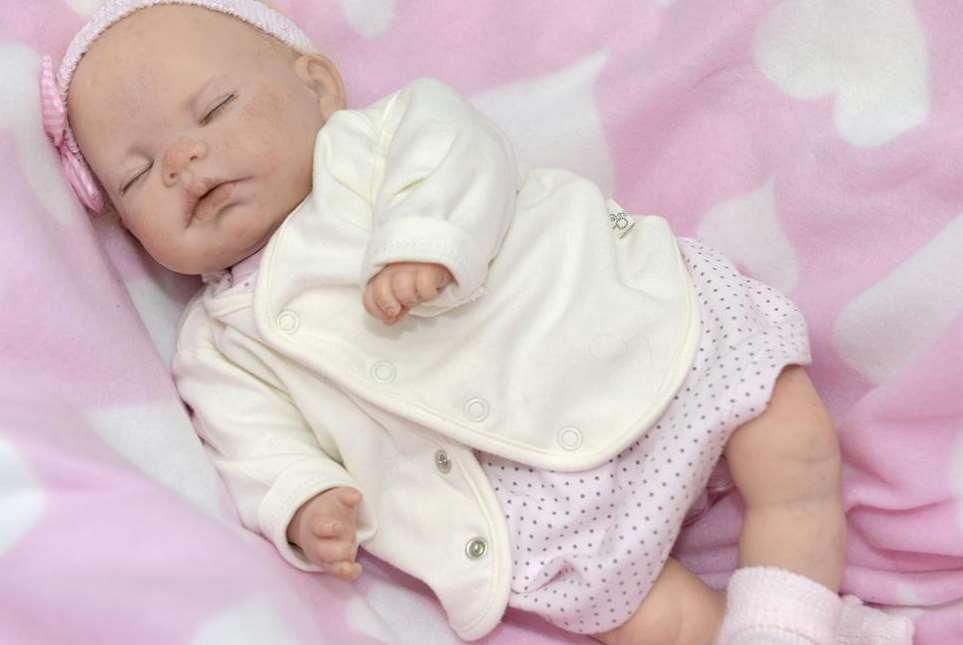 An ultra-realistic doll wearing baby clothes