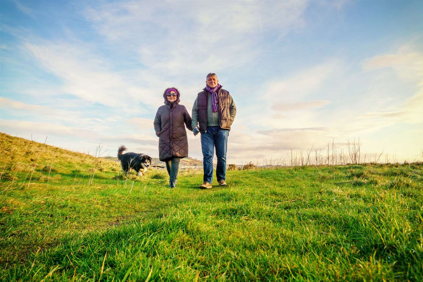 A couple out on a walk with their dog. Stock picture
