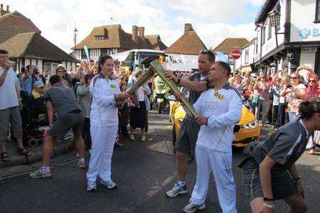 Caroline Spence lights David Hampson Ghani's torch before he sets off in Sandwich. Picture: Beth Robson